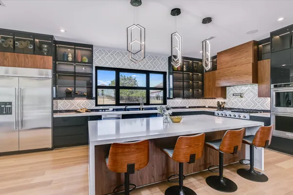 a kitchen with stainless steel appliances granite countertop a sink and a refrigerator