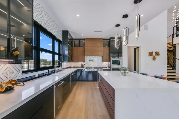 a large white kitchen with a large window