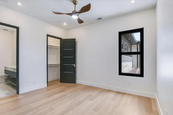 a view of an empty room with a window and a ceiling fan