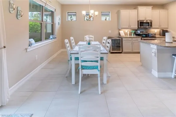 a kitchen with granite countertop a table chairs microwave and cabinets