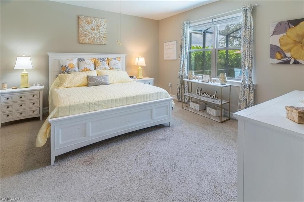 16366 Barclay Court Naples, FL 34110 - Photo 13 of 35 a spacious bedroom with a bed and a table