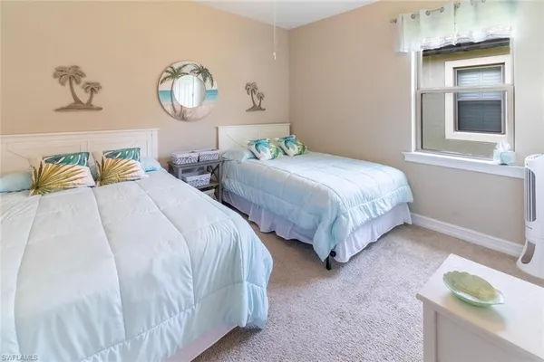 a bedroom with two beds and painting on the wall