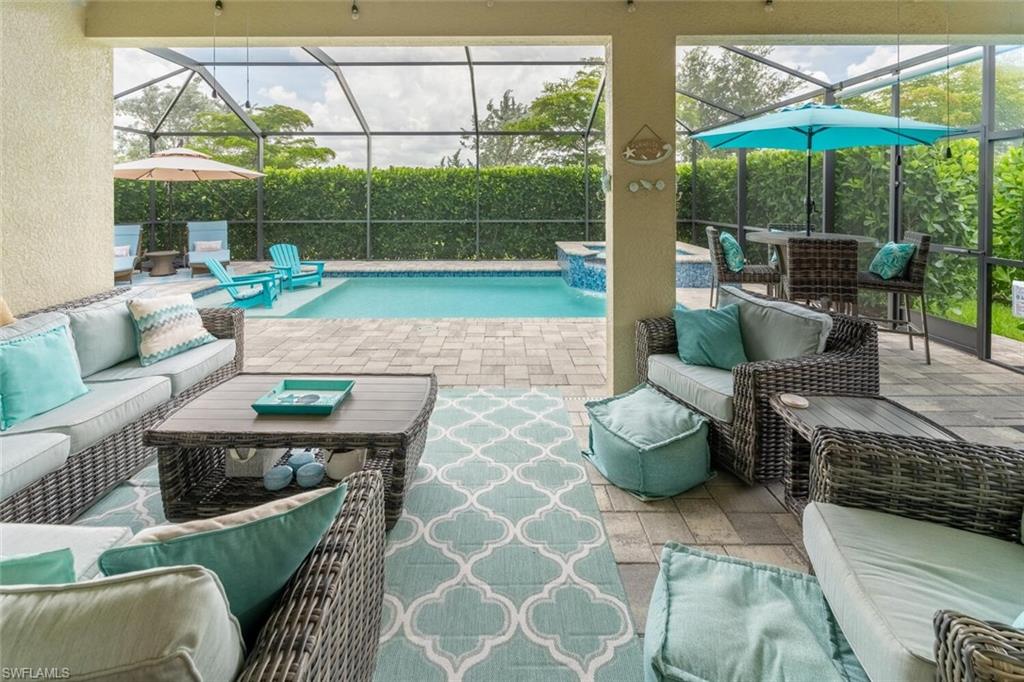 16366 Barclay Court Naples, FL 34110 - Photo 27 of 35 a living room with furniture and a floor to ceiling window