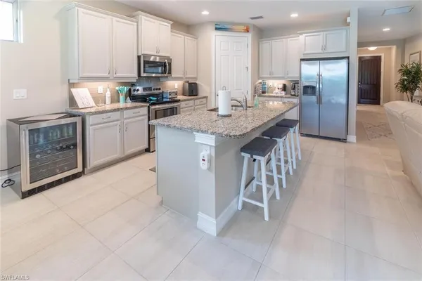 a kitchen with stainless steel appliances granite countertop a stove top oven a sink dishwasher a refrigerator and a cabinets