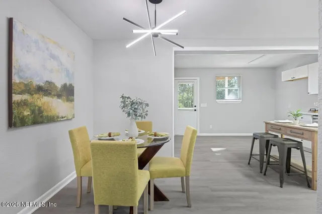 a dining room with furniture a window and wooden floor