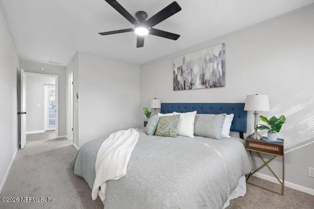 a bed room with a bed and a painting on the wall