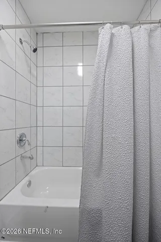 a bathroom with a shower and a bath tub