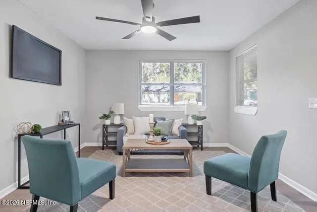 a living room with furniture a chandelier and a window