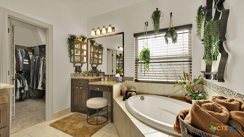 343 Meadow Valley Loop Jarrell, TX 76537 - Photo 18 of 33 a bathroom with a tub sink and mirror