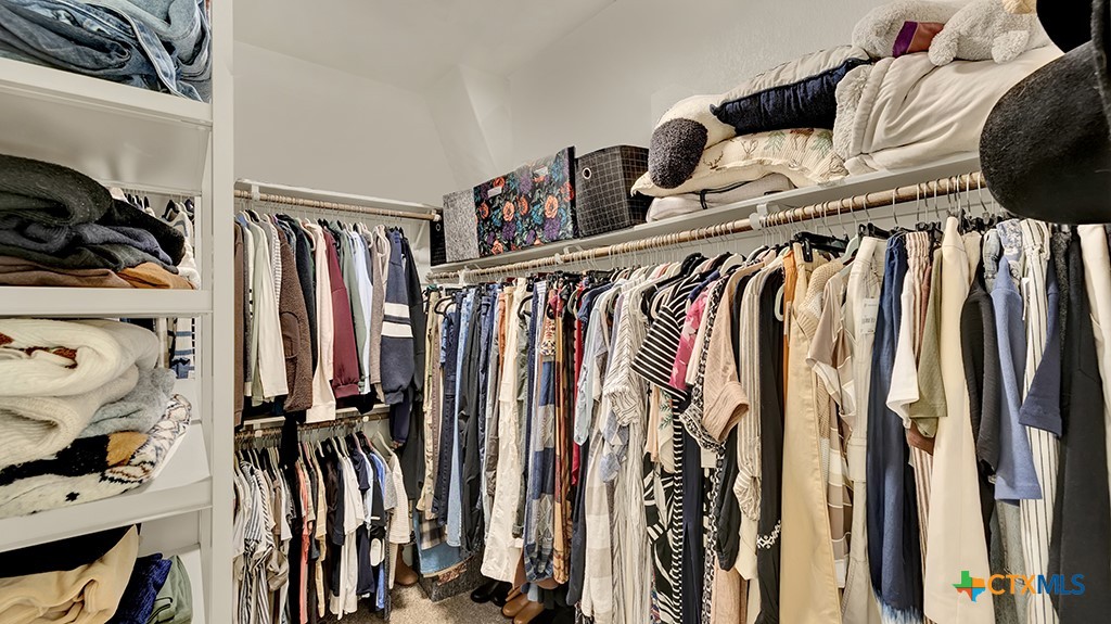 343 Meadow Valley Loop Jarrell, TX 76537 - Photo 20 of 33 a view of walk in closet with clothes and shoes