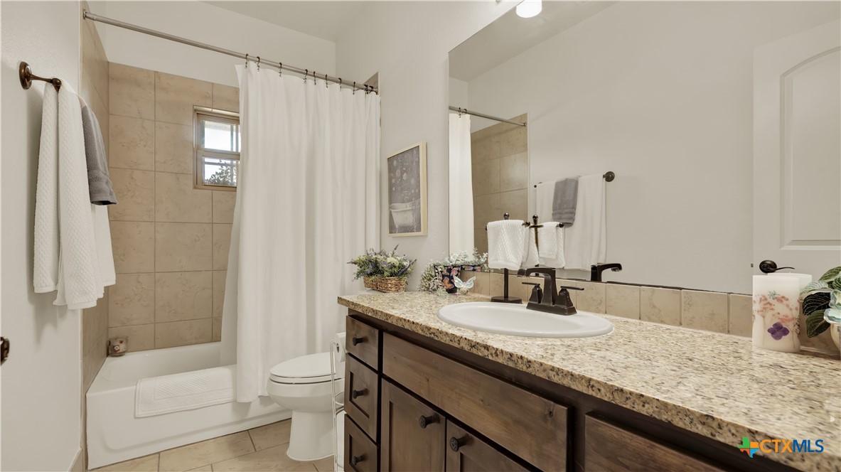 343 Meadow Valley Loop Jarrell, TX 76537 - Photo 10 of 33 a bathroom with a granite countertop sink toilet and shower