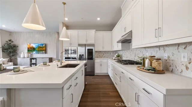 a kitchen with kitchen island granite countertop a sink a counter space appliances and cabinets
