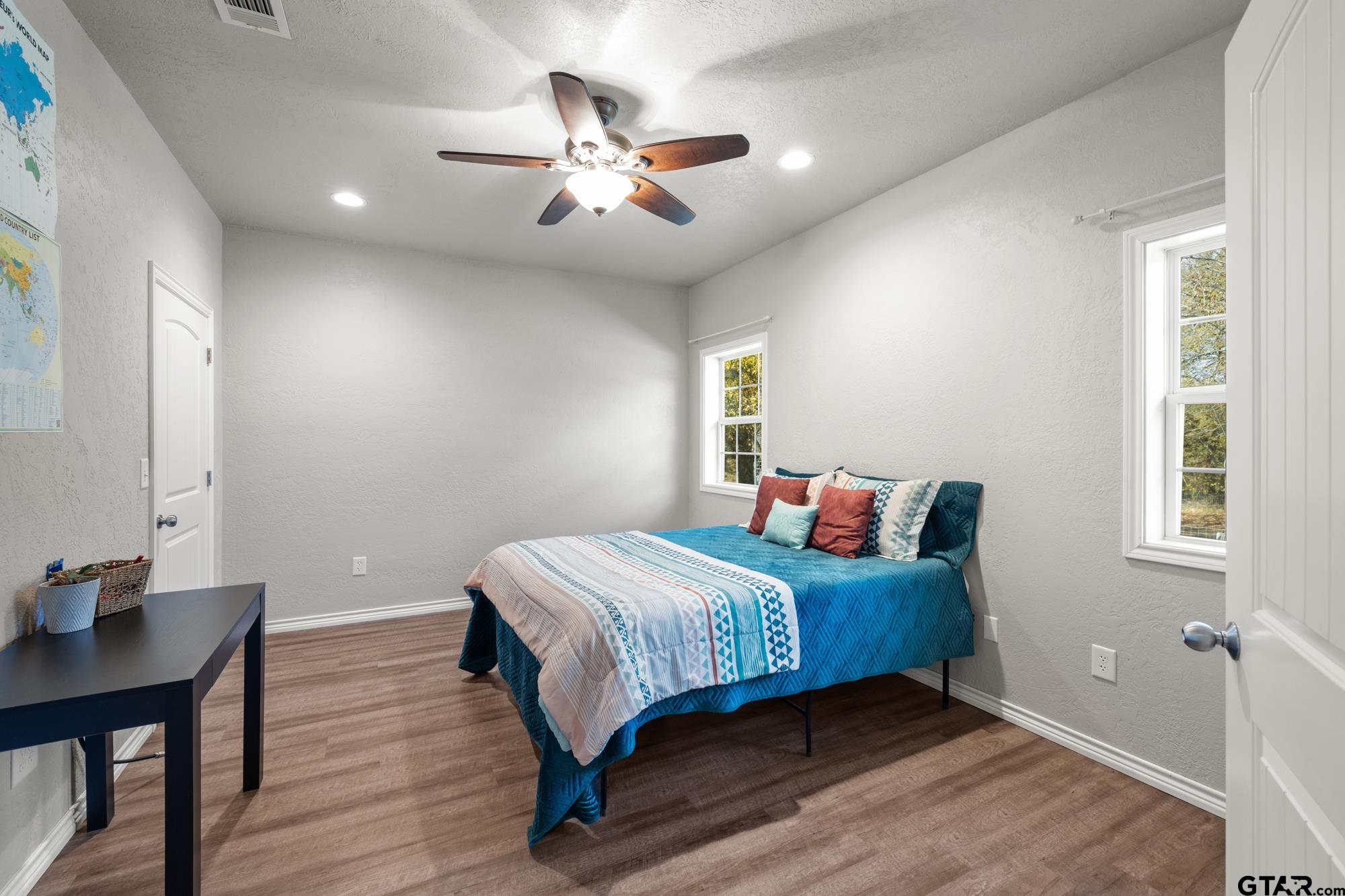 732 Red Maple Road Big Sandy, TX 75755 - Photo 16 of 40 a bedroom with a bed and a chandelier