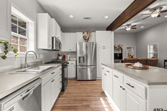 a kitchen with white cabinets and stainless steel appliances