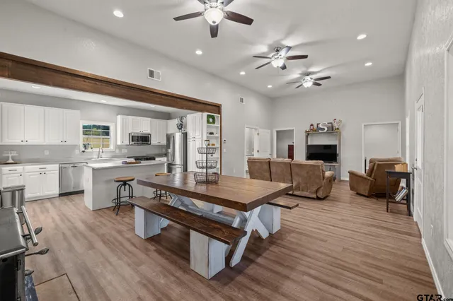 a living room with furniture kitchen view and a large window