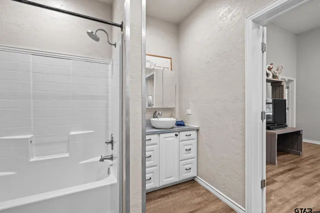 a bathroom with a shower a sink and a mirror