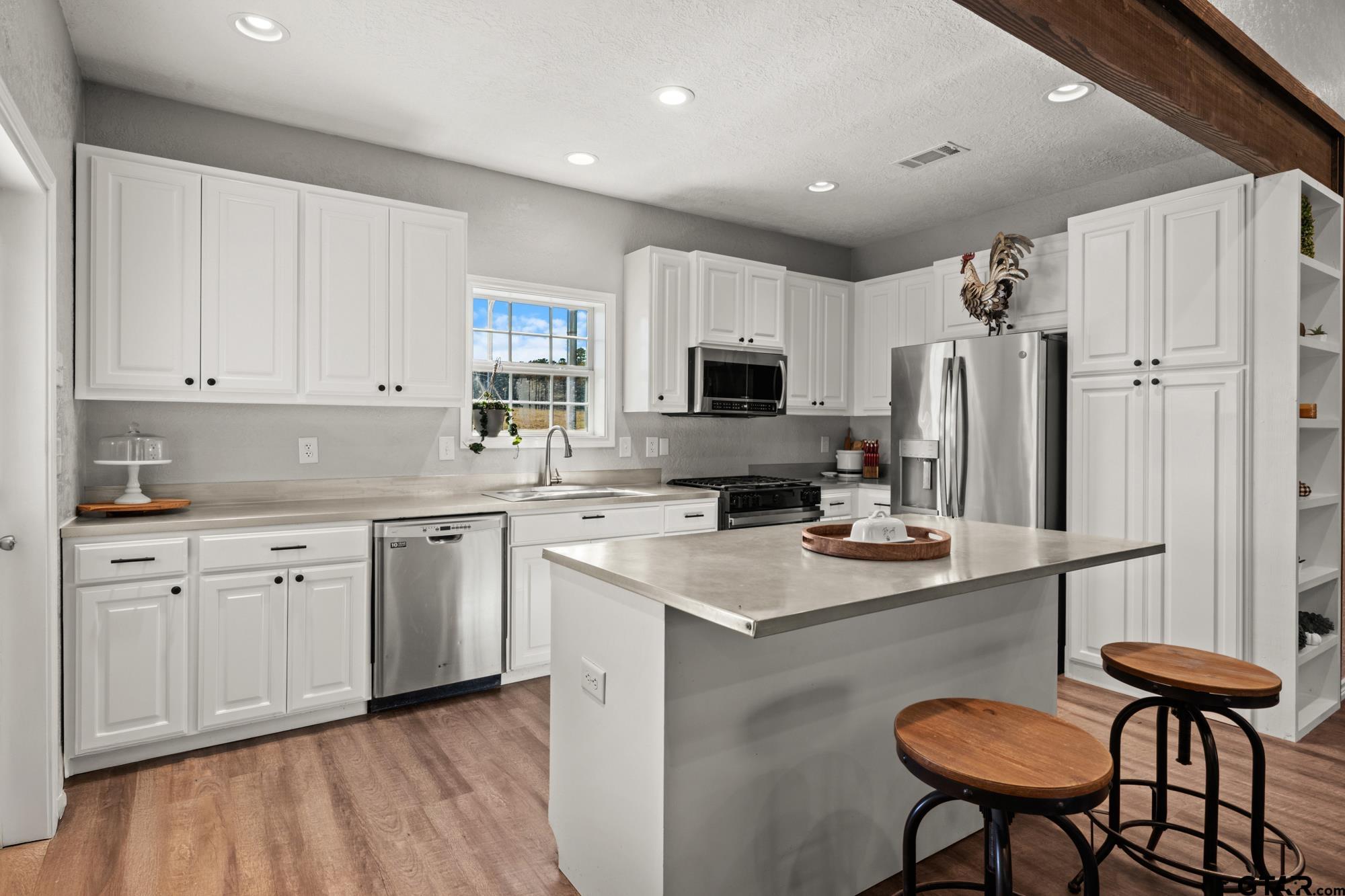 732 Red Maple Road Big Sandy, TX 75755 - Photo 9 of 40 a kitchen with stainless steel appliances a stove a sink refrigerator and a refrigerator with wooden floor
