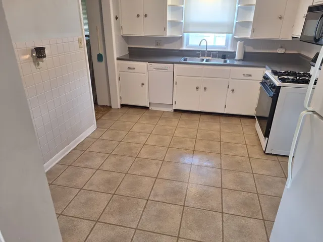 a kitchen with a sink a stove a refrigerator and cabinets