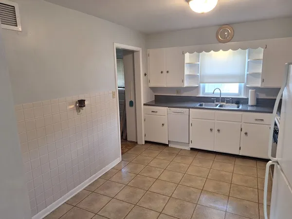 a bathroom with a granite countertop sink a mirror and a bathtub