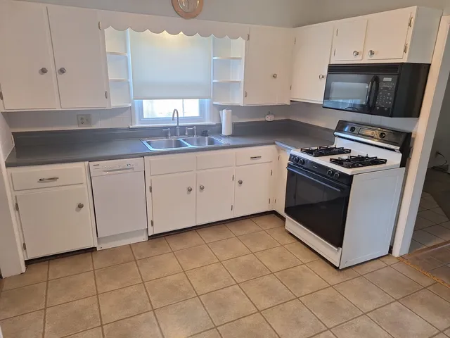 a kitchen with cabinets appliances and a sink