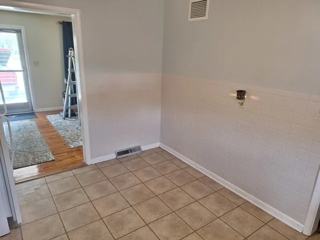 an empty room with kitchen view