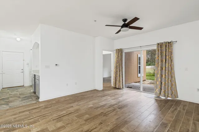 a view of a livingroom with wooden floor and a ceiling fan