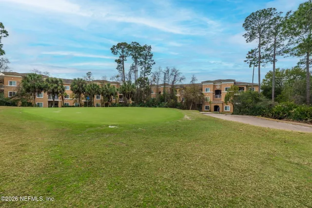 a view of a field with grass and trees