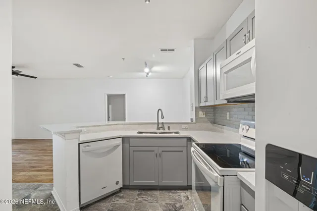 a kitchen with cabinets appliances a sink and a counter top