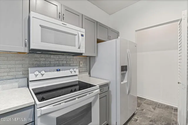 a kitchen with white cabinets and white appliances