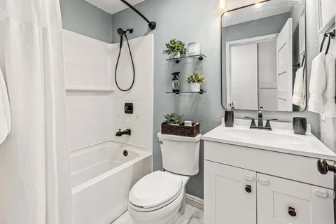 a bathroom with a toilet sink vanity tub and shower