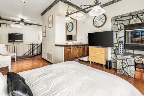 a bedroom with a bed and a flat tv screen on the dresser