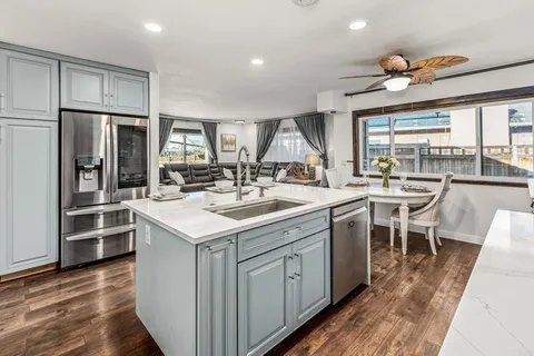 a kitchen with a sink stainless steel appliances and dining table