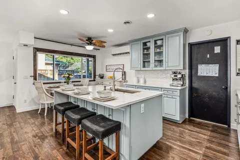 a kitchen with a sink and chairs