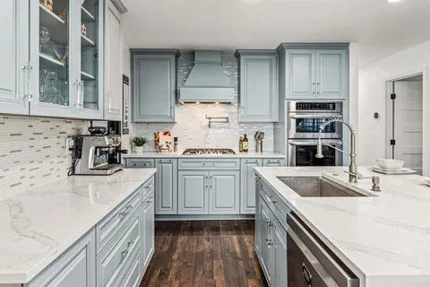 a kitchen with granite countertop a sink stove and cabinets