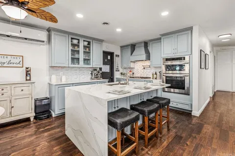 a kitchen with stainless steel appliances kitchen island granite countertop a sink and cabinets