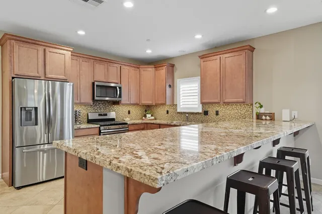 a kitchen with granite countertop a sink stainless steel appliances and cabinets