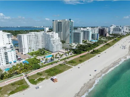 a view of a house with a big yard and large trees