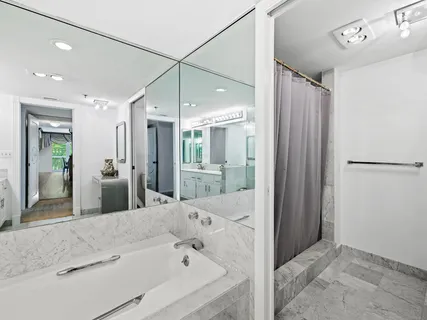 a bathroom with a tub shower and sink