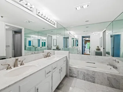 a bathroom with a granite countertop double vanity sink and mirror