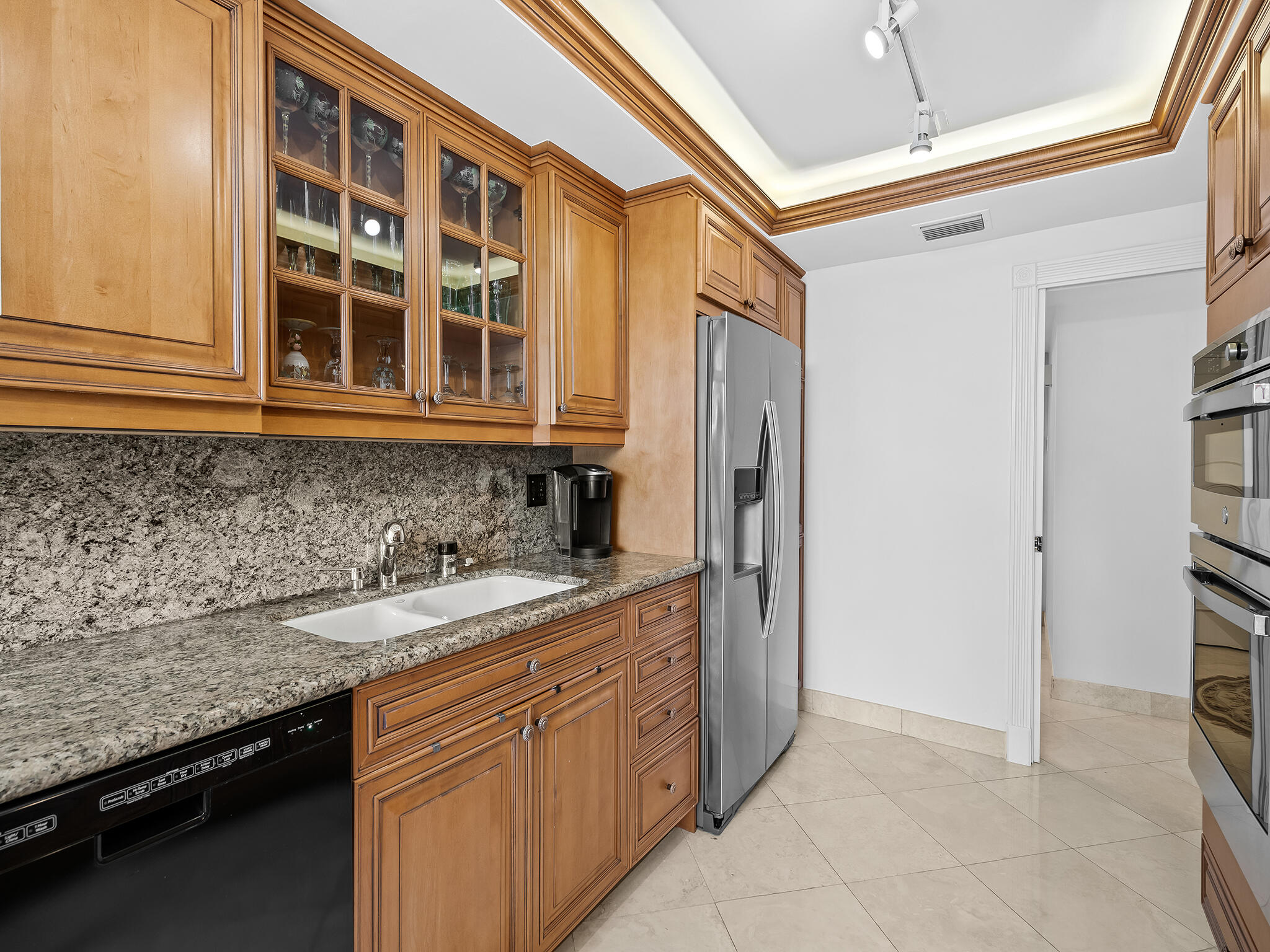 901 East Camino Real, Unit 4D Boca Raton, FL 33432 - Photo 10 of 37 a kitchen with a sink and a refrigerator
