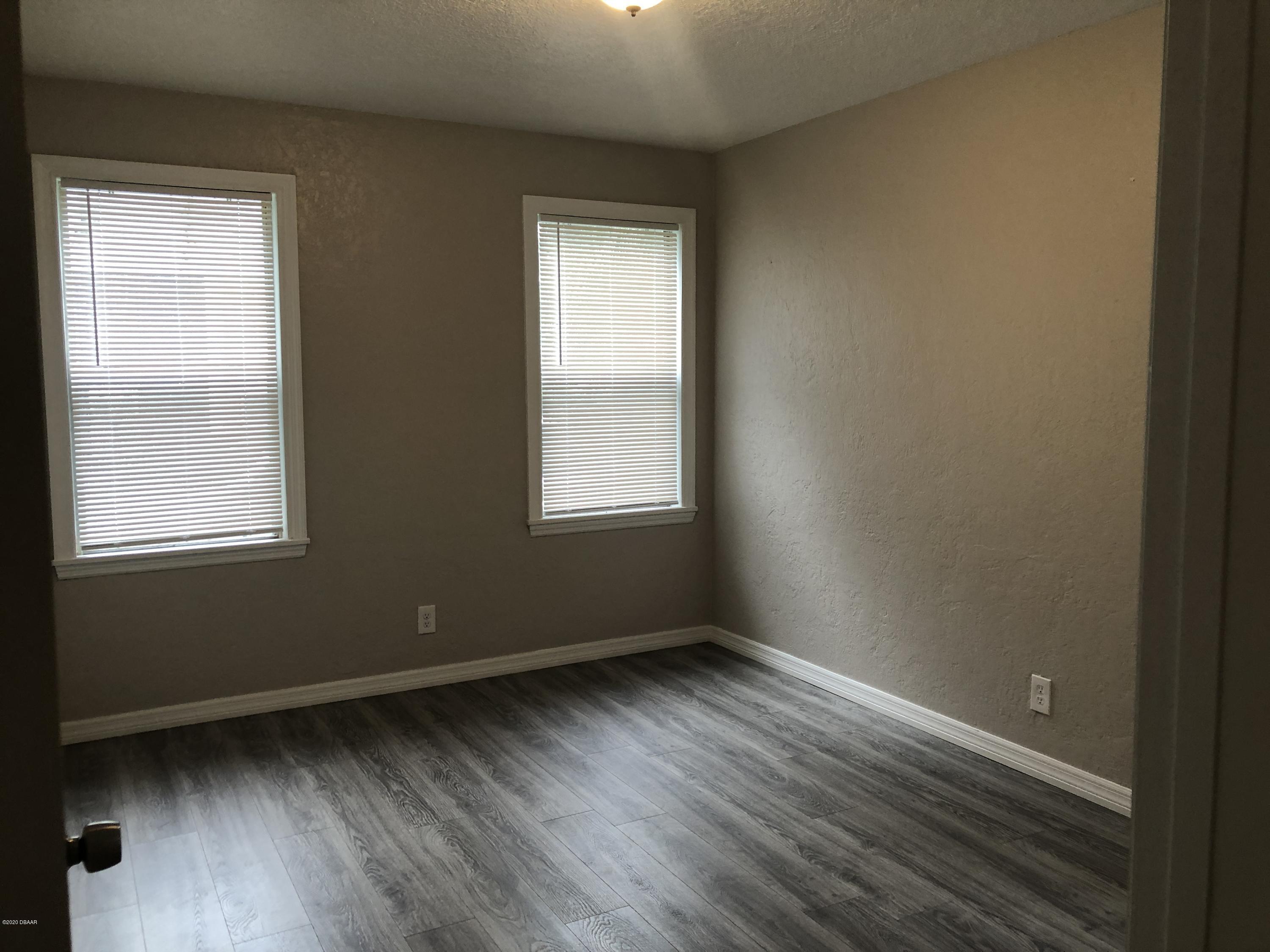 294 Roosevelt Drive Ormond Beach, FL 32174 - Photo 13 of 18 a view of an empty room with wooden floor and a window