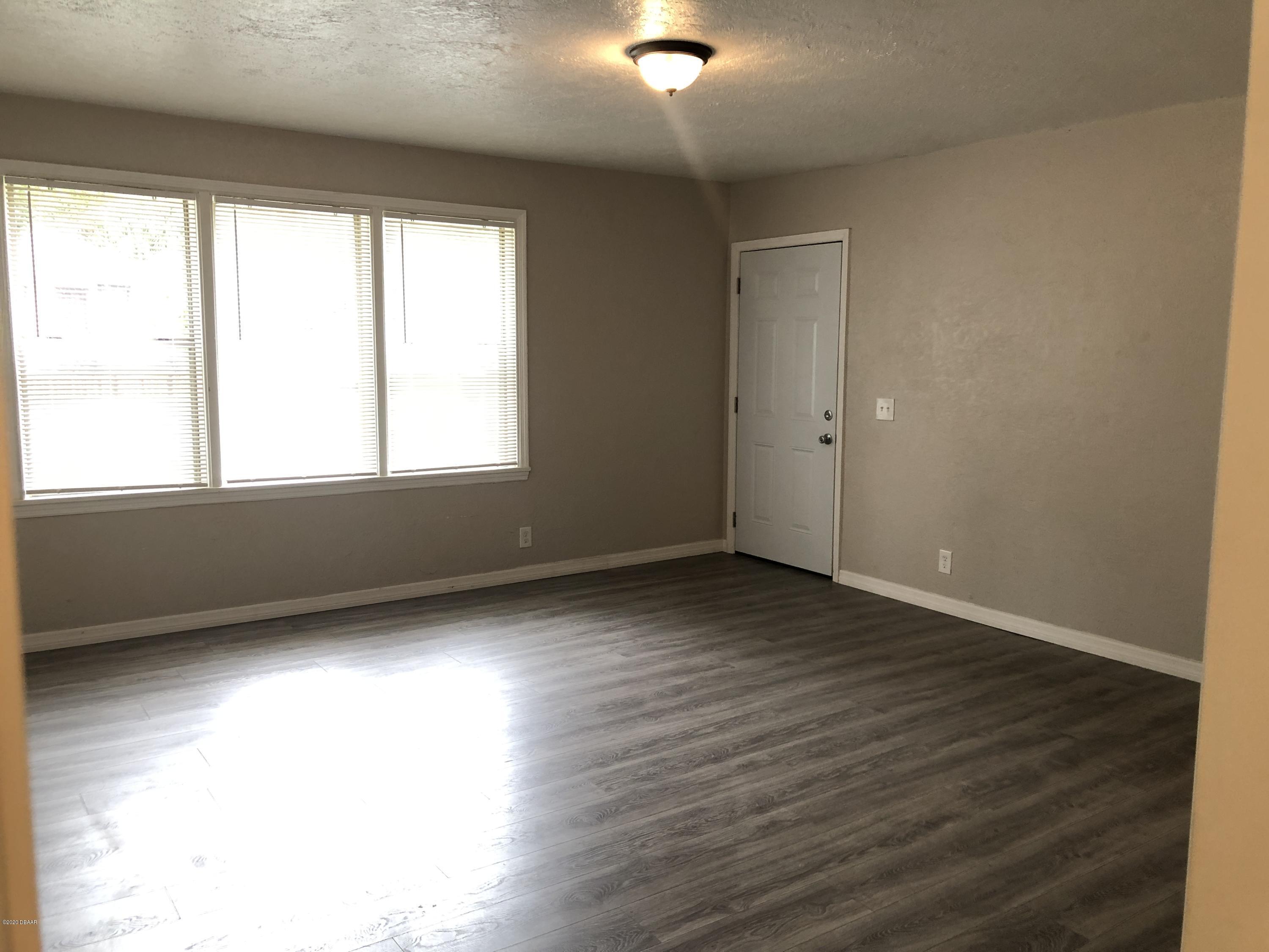 294 Roosevelt Drive Ormond Beach, FL 32174 - Photo 4 of 18 an empty room with wooden floor and windows