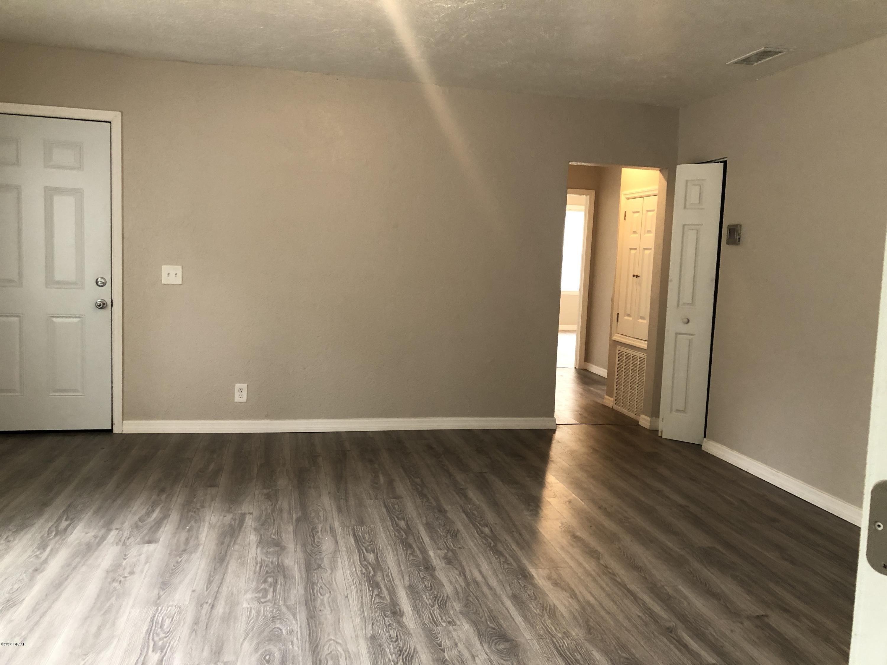 294 Roosevelt Drive Ormond Beach, FL 32174 - Photo 5 of 18 a view of an empty room with wooden floor and a window