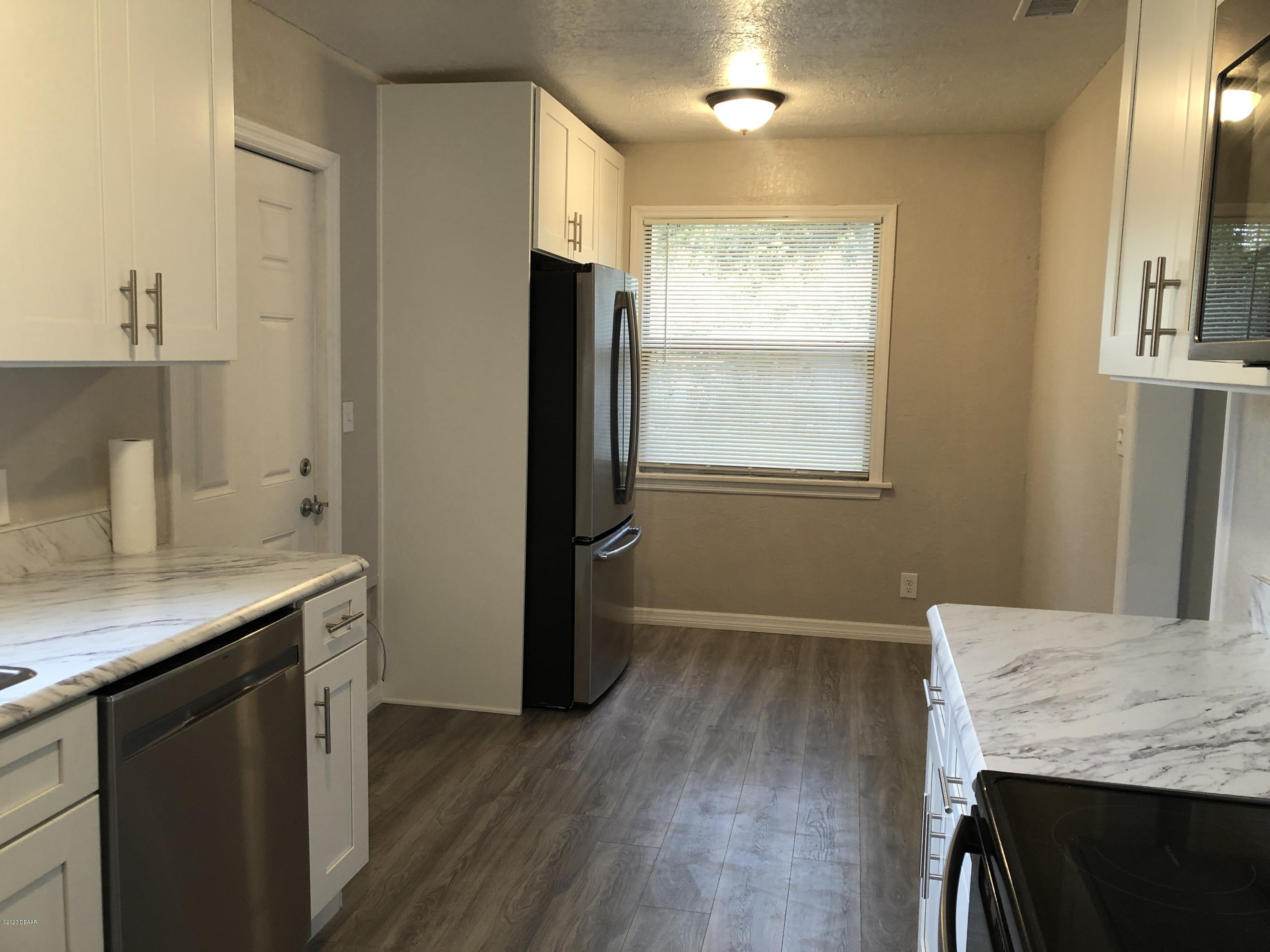 294 Roosevelt Drive Ormond Beach, FL 32174 - Photo 7 of 18 a kitchen with granite countertop a sink appliances and cabinets