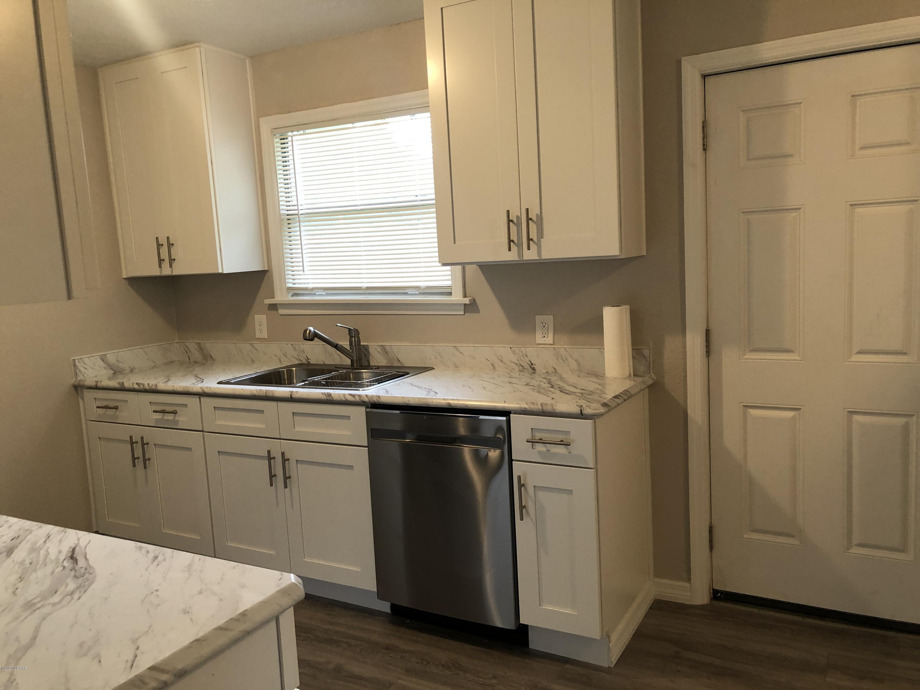 294 Roosevelt Drive Ormond Beach, FL 32174 - Photo 8 of 18 a kitchen with a sink cabinets and wooden floor