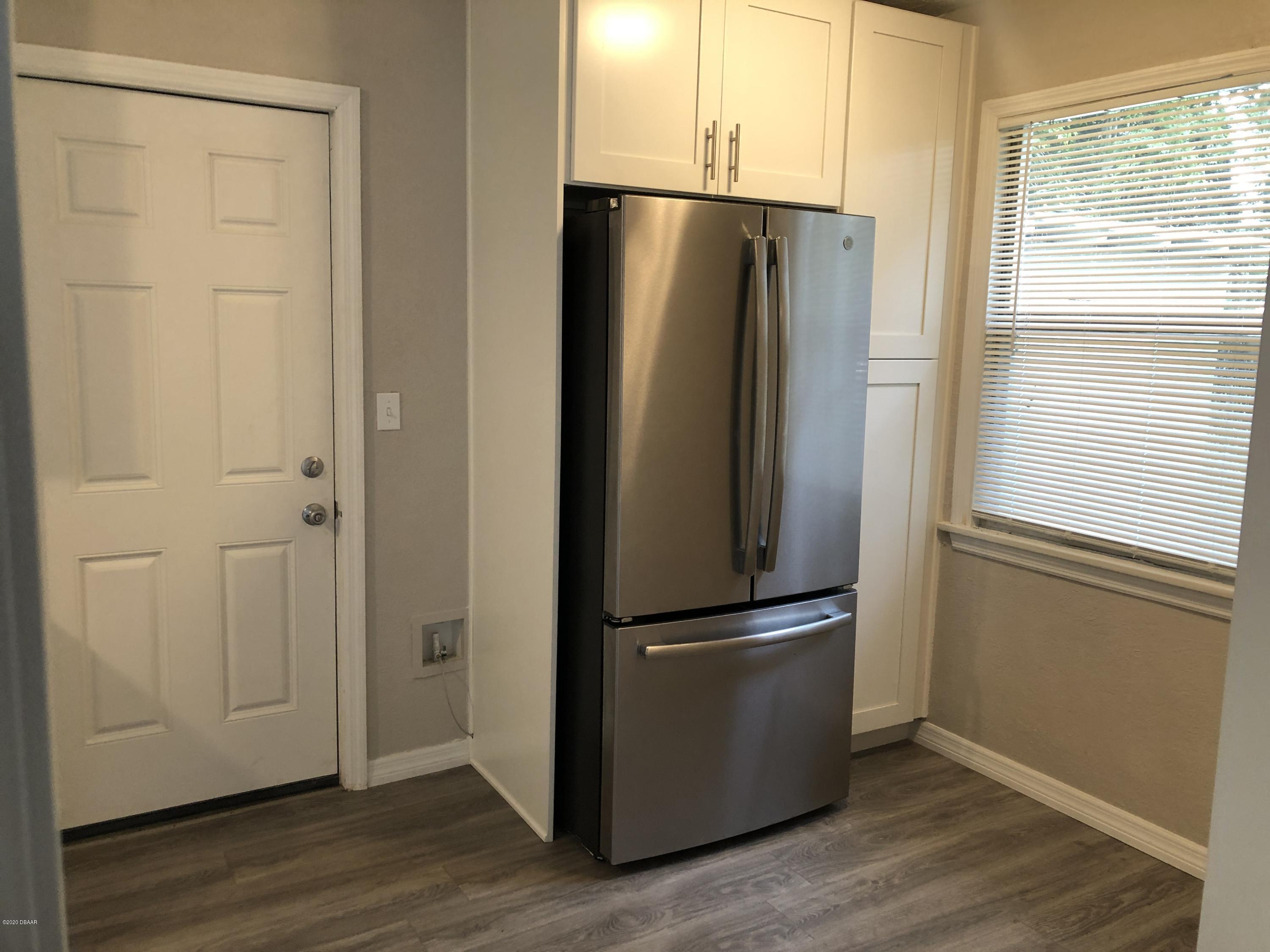 294 Roosevelt Drive Ormond Beach, FL 32174 - Photo 9 of 18 a view of a refrigerator in kitchen and wooden floor