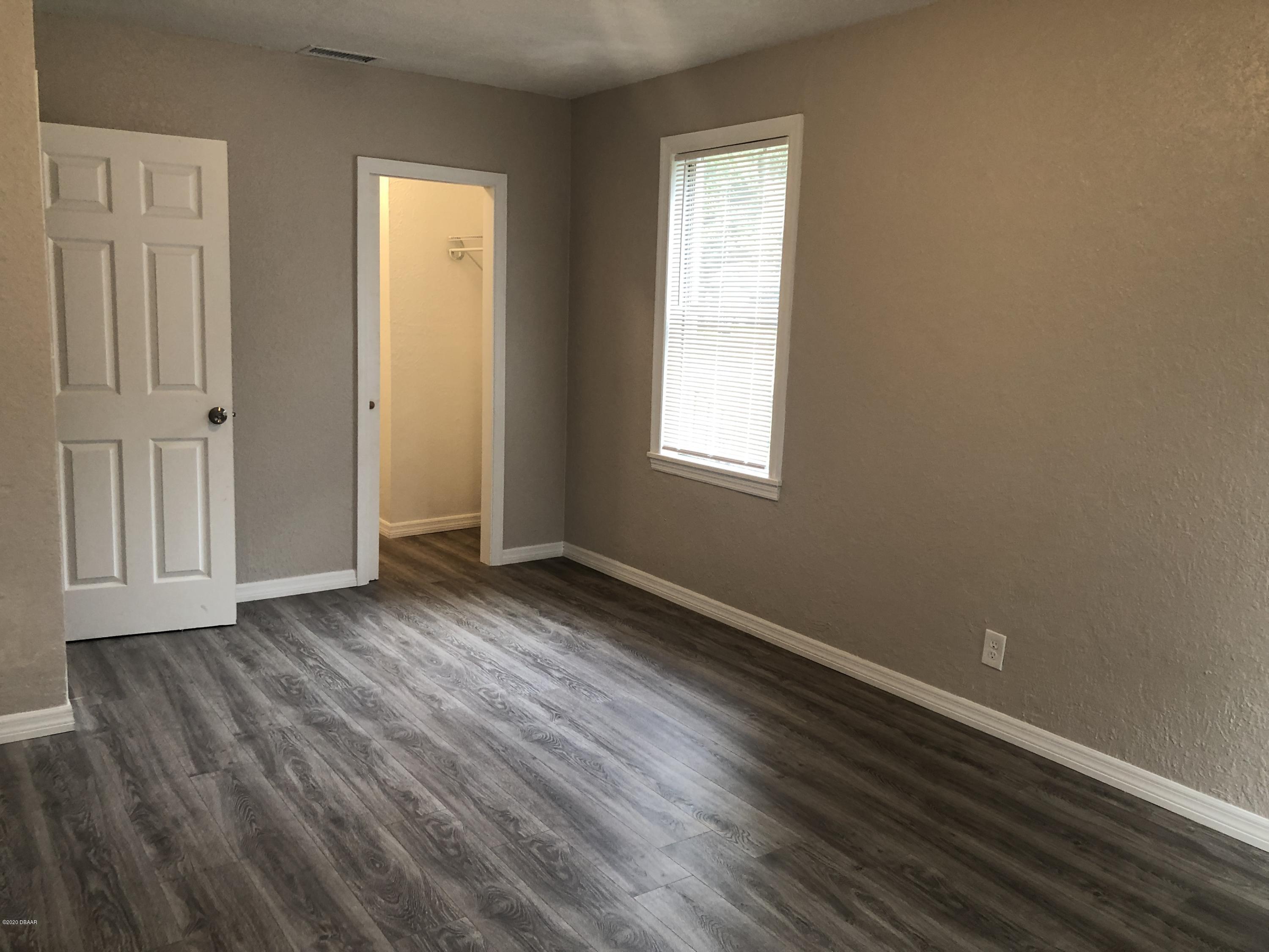 294 Roosevelt Drive Ormond Beach, FL 32174 - Photo 10 of 18 an empty room with wooden floor and windows