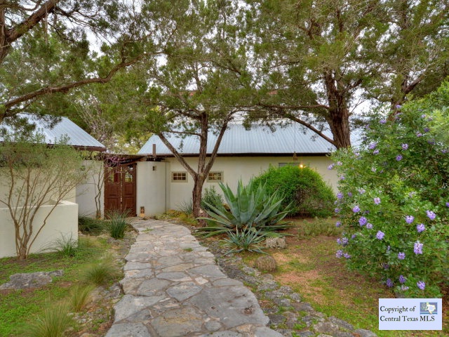 1515 Caliche Road Wimberley, TX 78676 - Photo 1 of 1 a front view of a house with garden