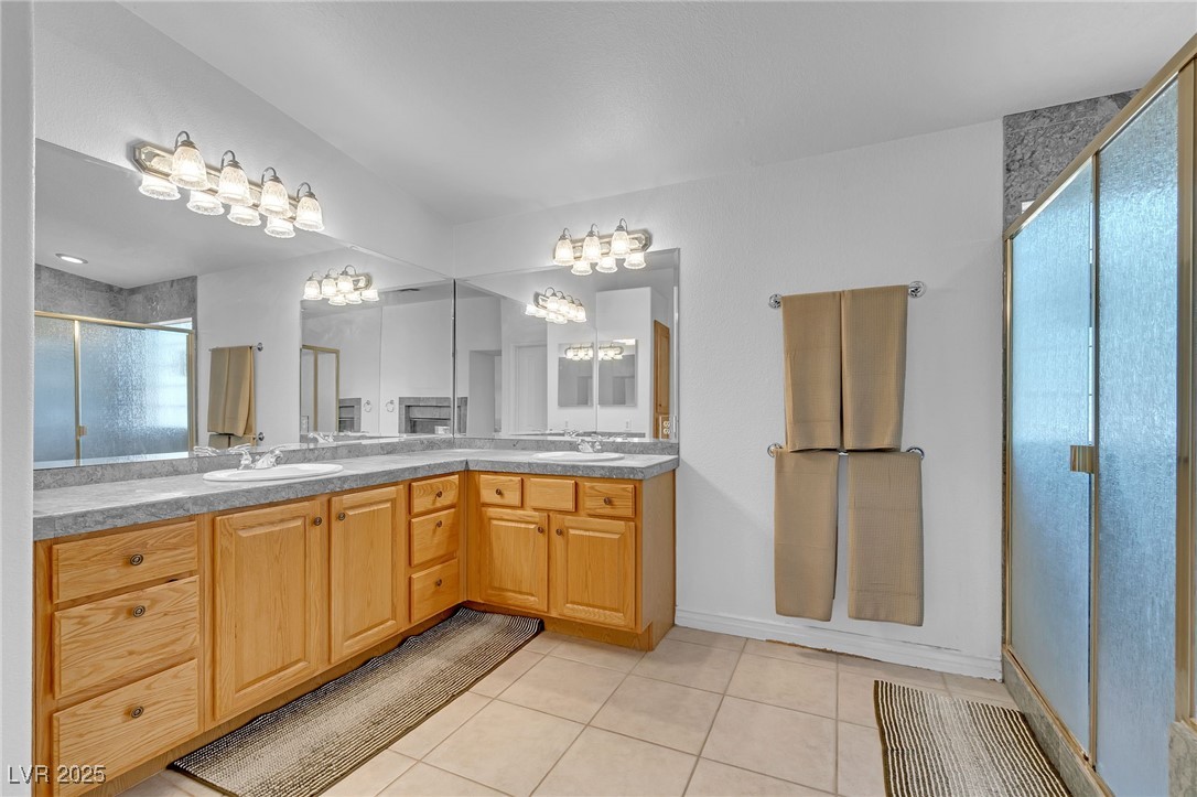 655 Florence Drive Boulder City, NV 89005 - Photo 33 of 63 Full bathroom with double vanity, light tile patterned floors, a shower stall, and a chandelier