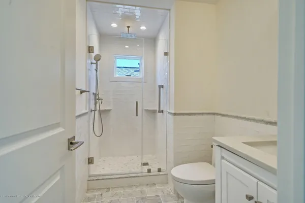 a bathroom with a granite countertop sink toilet and shower